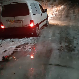 При скатывании с ледяной горки левая сторона машины провалилась в снег вытащить застрявшую машину Пежо Парнер