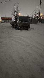 прошу помощи, застрял автомобиль во дворе в снегу, помогите пожалуйста в гору его вытянуть. .  вытащить застрявшую машину Isuzu nqr