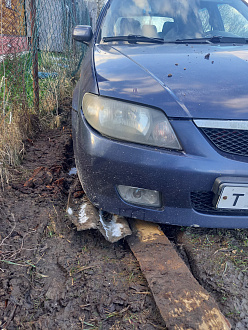 помогите пожалуйста, сташило с колеи в жидкую землю. вытащить застрявшую машину Mazda 323F 