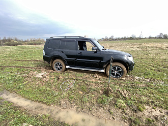 помогите, застрял в грязи, вроде и не глубоко, но резина запылилась и всё вытащить застрявшую машину Мицубиси Паджеро