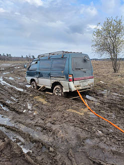 Машина застряла в поле, в 100 метрах от конечной остановки автобуса, заполнение колеса в грязи, передние в луже, есть трос динамический, есть за что цеплять вытащить застрявшую машину Mitsubishi Delica