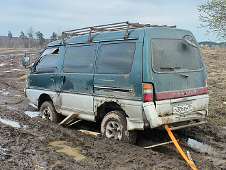 Машина застряла в поле, в 100 метрах от конечной остановки автобуса, заполнение колеса в грязи, передние в луже, есть трос динамический, есть за что цеплять вытащить застрявшую машину Mitsubishi Delica